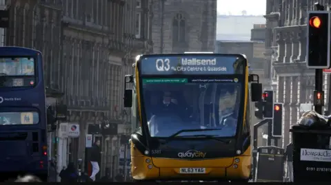 LDRS A yellow bus with a Q3 sign climbs up a hill in Newcastle City Centre.