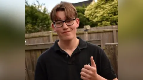 Leicestershire Police Jack Woodward, who has brown hair with a middle parting, wearing glasses and a black collared polo shirt.