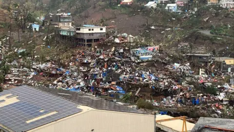 [AFP]Destroyed houses and rubble line the hills of Mayotte