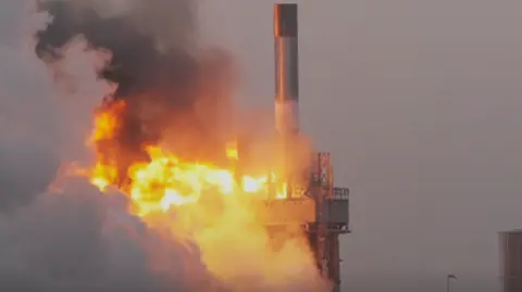 rocket explosion, flames and smoke bellowing from the launch pad below the rocket