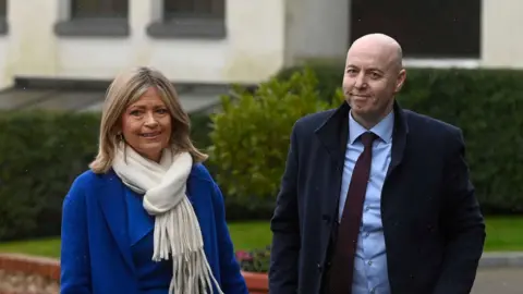 Mark Marlow/PA Wire Armstrong has shoulder length blonde hair and is wearing a blue coat and white scarf. Burrows is bald and is wearing a dark coat, light coloured shirt and dark tie.