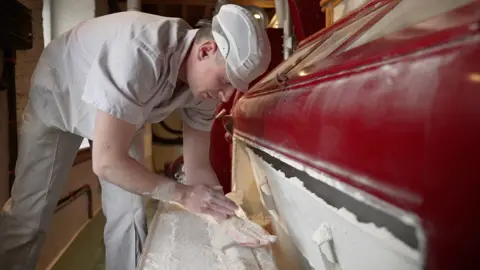BBC/Kevin Church A miller examining flour