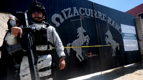 Getty Images National Guard officers stand guard while members of the collective "Guerreros Buscadores" visit the Izaguirre ranch, where on March 5 they located three human crematory ovens 