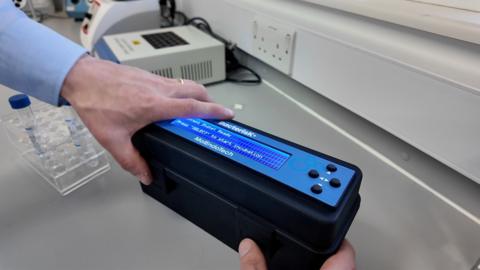 Black box for testing water samples with an illuminated screen to display results 