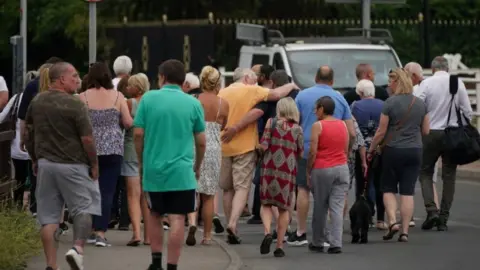 PA Media Residents of Wennington hugging each other