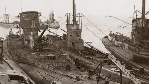 Getty Images A stereo card image of German submarines moored at Harwich at the end of World War I, November 1918. The vessels were surrendered to Britain under the terms of the armistice signed by Germany.