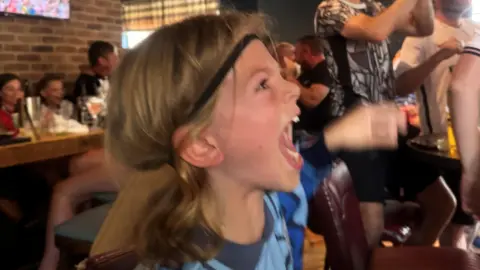 Jess Clark A young child is cheering on England