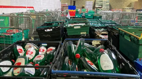 Pallets containing household items including washing-up liquid.
