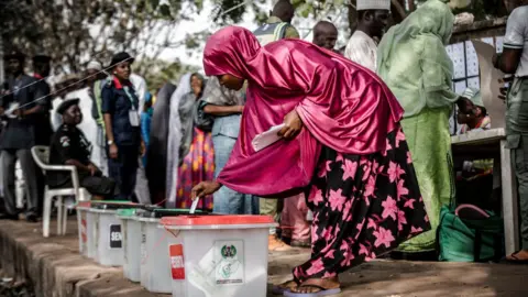 AFP Nigerian woman casts her vote for a candidate in the presidential election at Agiya polling station a few hours before polls opened in Yola, Adamawa State, Nigeria on 23 February 2019