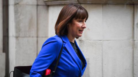 Shadow chancellor Rachel Reeves wearing a blue jacket and carrying a black bag