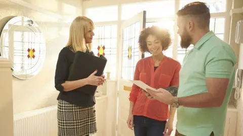 Getty Images A couple viewing a house with an estate agent