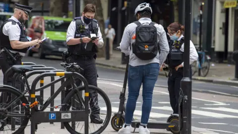 Getty Images Police stop a man with an e-scooter