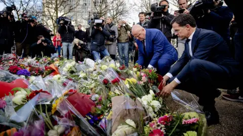AFP Dutch PM Mark Rutte and Justice Minister Ferdinand Grapperhaus (2nd R) laid flowers close to the scene of the attack