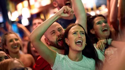 England fans celebrate their team's goal as they watch a live screening of the UEFA Euro 2024 final football match between Spain and England being played in Berlin, inside a pub in central London on July 14, 2024. 