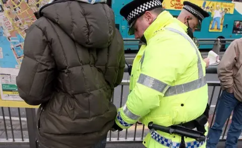 Getty Images Officer carrying out stop and search