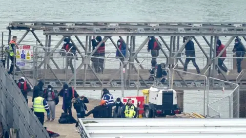 PA Media A group of people thought to be migrants are brought in to Dover, Kent, onboard a Border Force vessel following a small boat incident in the Channel