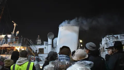 Bristol Film Office Image of the crew filming at night at Princes Wharf. Lots of people can be seen looking towards a boat.