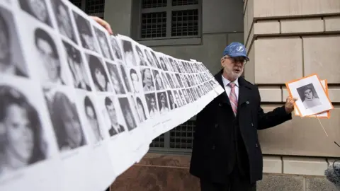 EPA Paul Hudson holds up pictures of the Lockerbie bombing