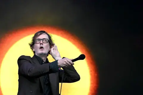 EPA Jarvis Cocker holds his microphone out to the audience during Pulp's headline set