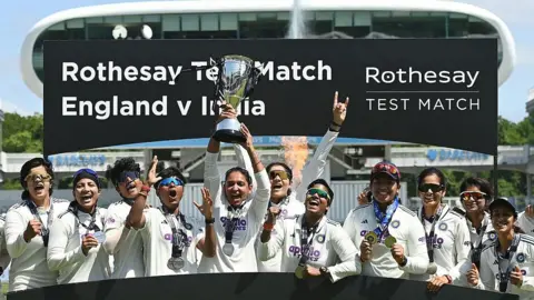 Getty Images India captain Harmanpreet Kaur holds the trophy up after India won the 1st Women's Rothesay Test match against England at Lord's Cricket Ground on July 13, 2026 in London, England. (Photo by Philip Brown/Getty Images)