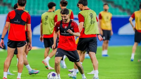 Iraq national team players warm-up on a football pitch