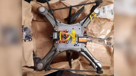 The seized domestic drone is displayed on brown paper