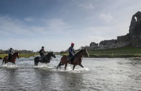 PA Media Horses from Christian Williams" stables in the river next to Ogmore Castle at his yard in Glamorgan. PA Photo. Picture date: Saturday March 21, 2020. All horse racing fixtures in Great Britain have been suspended until the end of April because of the coronavirus outbreak.