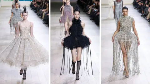 Getty Images Three women appear in Dior designs, including one in a full dress with tutu skirt and two others in lampshade style dresses complete with tassels.