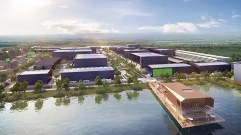 An aerial perspective of a large, modern development situated beside a sizeable body of water in the foreground. Multiple block-like buildings are arranged in a structured grid, with tree-lined pathways and open spaces running between them. A wooden waterside structure extends over the lake, featuring seating areas and terraces along the edge. In the distance, the surrounding landscape stretches out into open countryside under a bright sky with soft cloud cover.