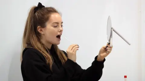 WPA Pool Kitty Ritchie demonstrates how to take a coronavirus test at a new walk-through testing centre