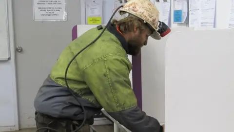 AEC A miner votes in a polling booth