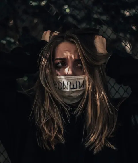 @_du_you Image of a woman with a mask which has 'breathe' written on it in Russian