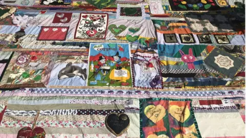 A large patchwork quilt sewn by survivors of the tragedy