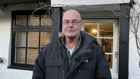 Charlotte Rose/BBC Nigel Dawson outside his home in Cambridgeshire.