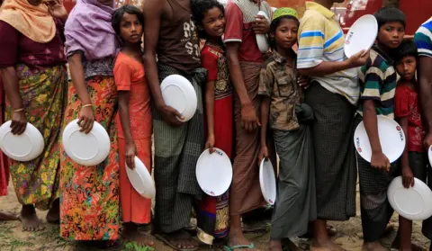 Zohra Bensemra/ Reuters Rohingya refugees line up with plates.