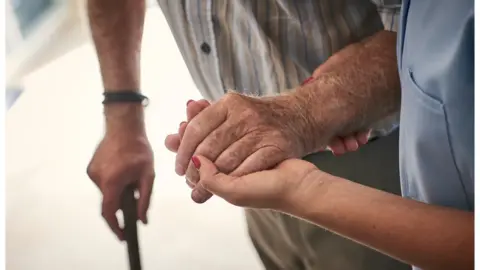 Getty Images Nurse helping older person