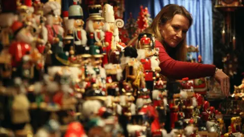 Getty Images A stall holder arranges her display of Christmas decorations at Birmingham's Frankfurt Christmas market