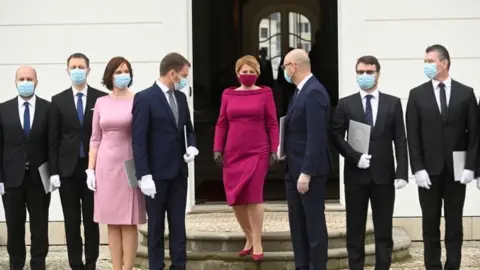 Reuters Slovakia's President Zuzana Caputova wears a protective face mask and poses for a photo with new members of the Slovak government