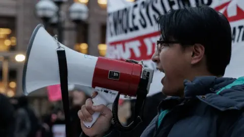 Man with megaphone at an anti-ICE rally in Minneapolis