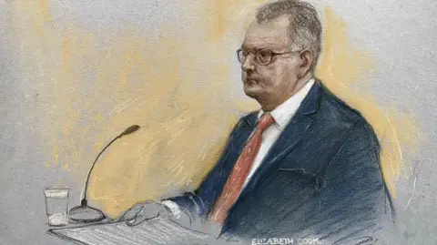PA Media A court sketch of Jeffrey Donaldson at his trial wearing a suit and red tie.