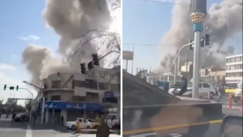 Smoke billows from buildings near an intersection.