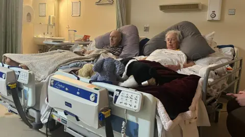 A dying couple in hospice beds placed side by side