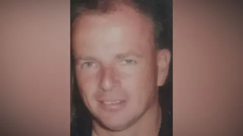 Contributed A man with dark hair smiles at the camera. He is wearing a black top. 