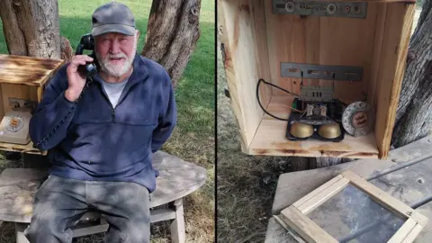 A composite photo of two images. On the left is a man in a grey cap, a navy fleece and grey jeans holding a black dial phone with a cord up to his ear. He is smiling and sitting on a bench next to a tree. A wooden box with a cream dial phone holder inside it is next to him. On the right is a close-up of the box which has been damaged and the dial phone ripped from its shell.