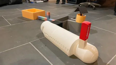 Plastic scale model of an aircraft fuselage connected to other structures.