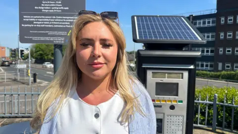 Chloe Daynes, standing by one of the ticket machines