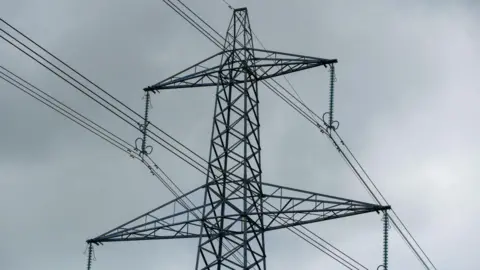 A pylon in front of a cloudy grey sky.