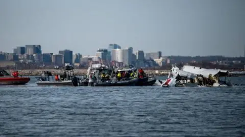 U.S. Coast Guard, along with other search and rescue teams, operate near debris at the crash site in the Potomac River in a location given as Washington, in the aftermath of the collision of American Eagle flight 5342 and a Black Hawk helicopter that crashed into the Potomac River, U.S. January 30, 2025.