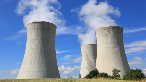 Getty Images Three large power plant chimneys pumping out steam