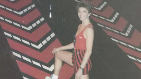 Nicola Bawden Nicola Bawden on the gladiators posing with one leg up on the escalator style device. She is wearing her gladiators attire.